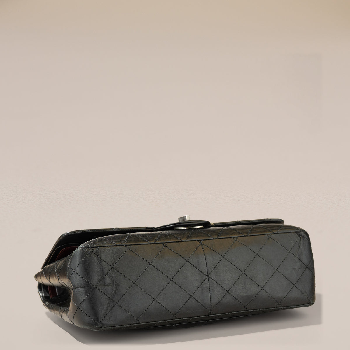 Chanel 2.55 Reissue 227, Black Aged Calfskin — base, angle