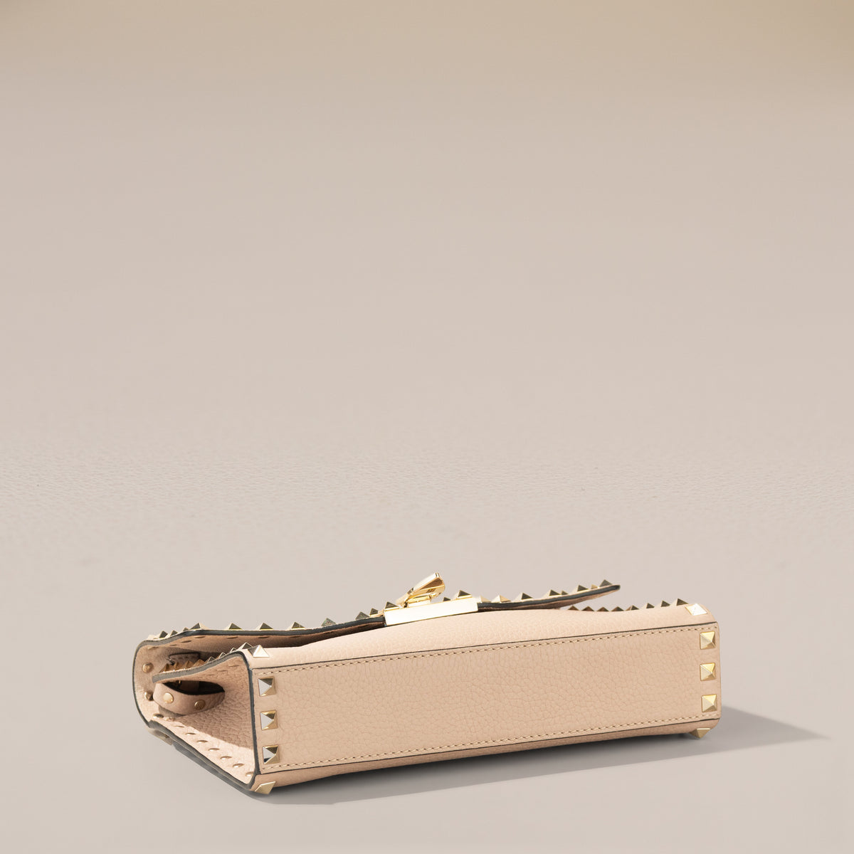Valentino Garavani Small Rockstud Crossbody, Poudre Grainy Calfskin — base, angle