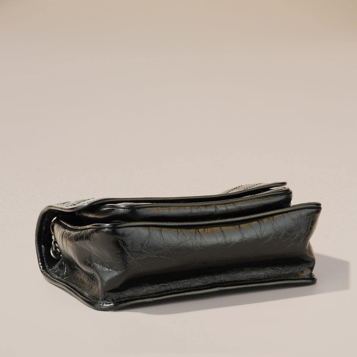 Saint Laurent Niki Baby, Black Crinkled Vintage Leather — base, angle